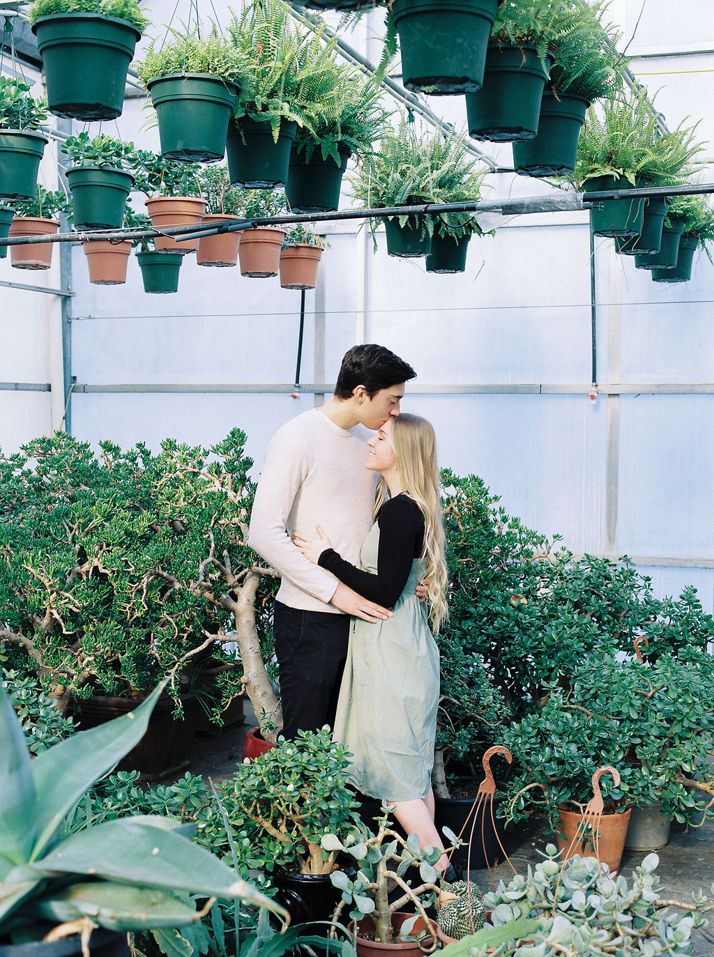 Engaged Couple Greenhouse Forehead Kiss