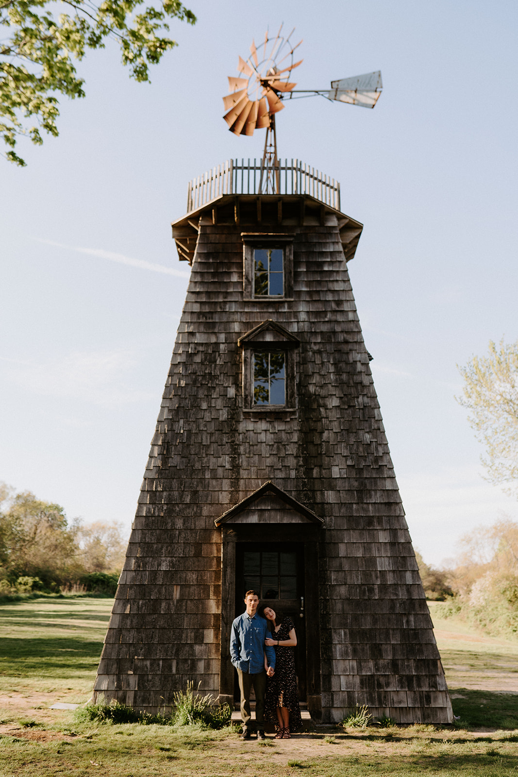 couple hugging in front of light house during engagement session