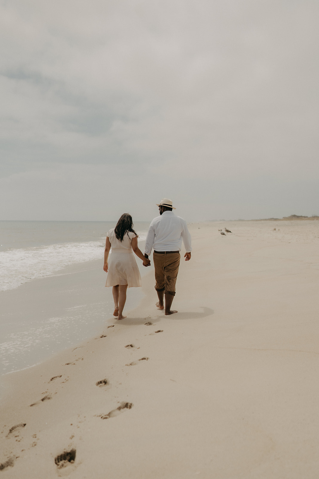 engagement shoot with couple walking on beach