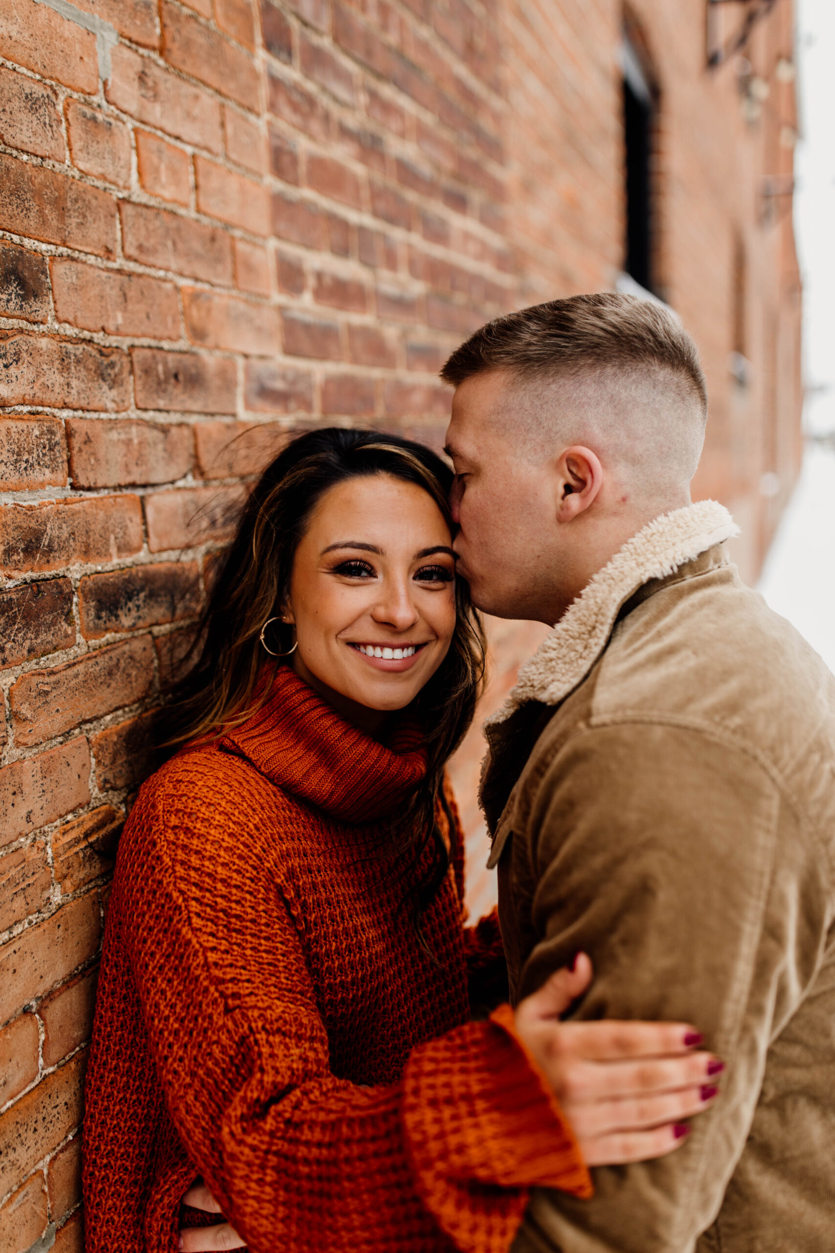 Engaged Couple Head Kiss Brick Wall