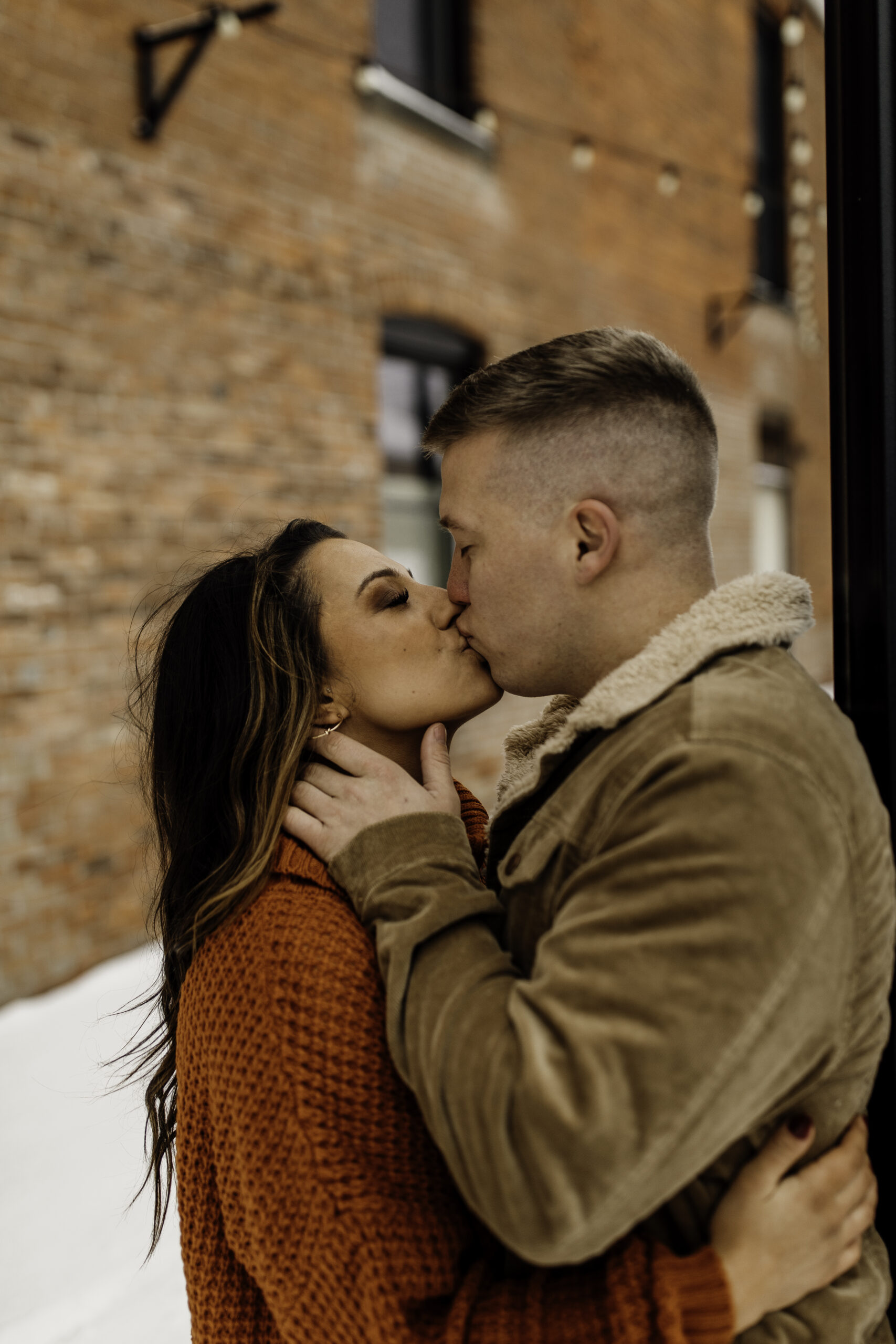 Engaged Couple Kiss Brick Wall
